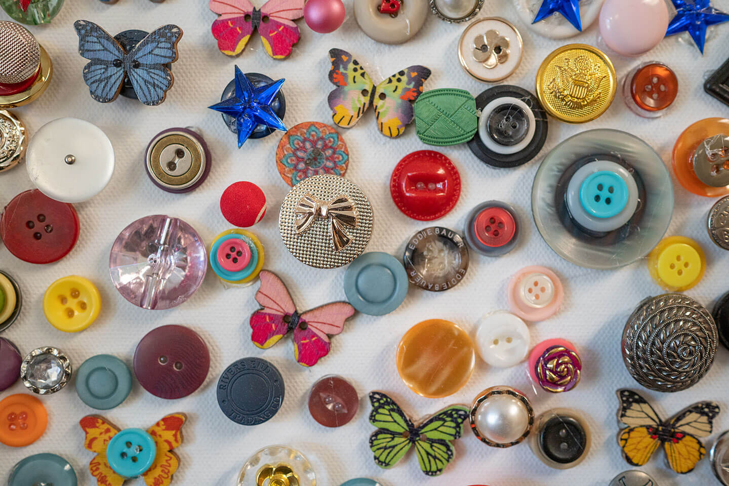 Colorful buttons of different shapes laid out on a white surface.