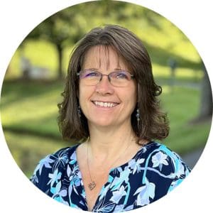 A portrait of Jennifer Kincaid, Chief People Officer for Hospice of the Piedmont. She has medium length brown hair and wears a blue floral blouse.