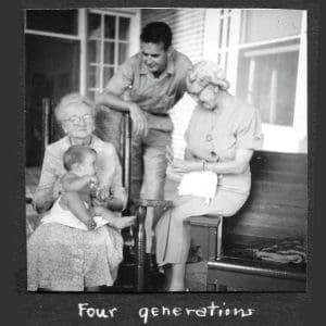 Four generations of one family as seen in a black and white photo from the 1950's. A baby, his father, his grandmother, and his great grandmother