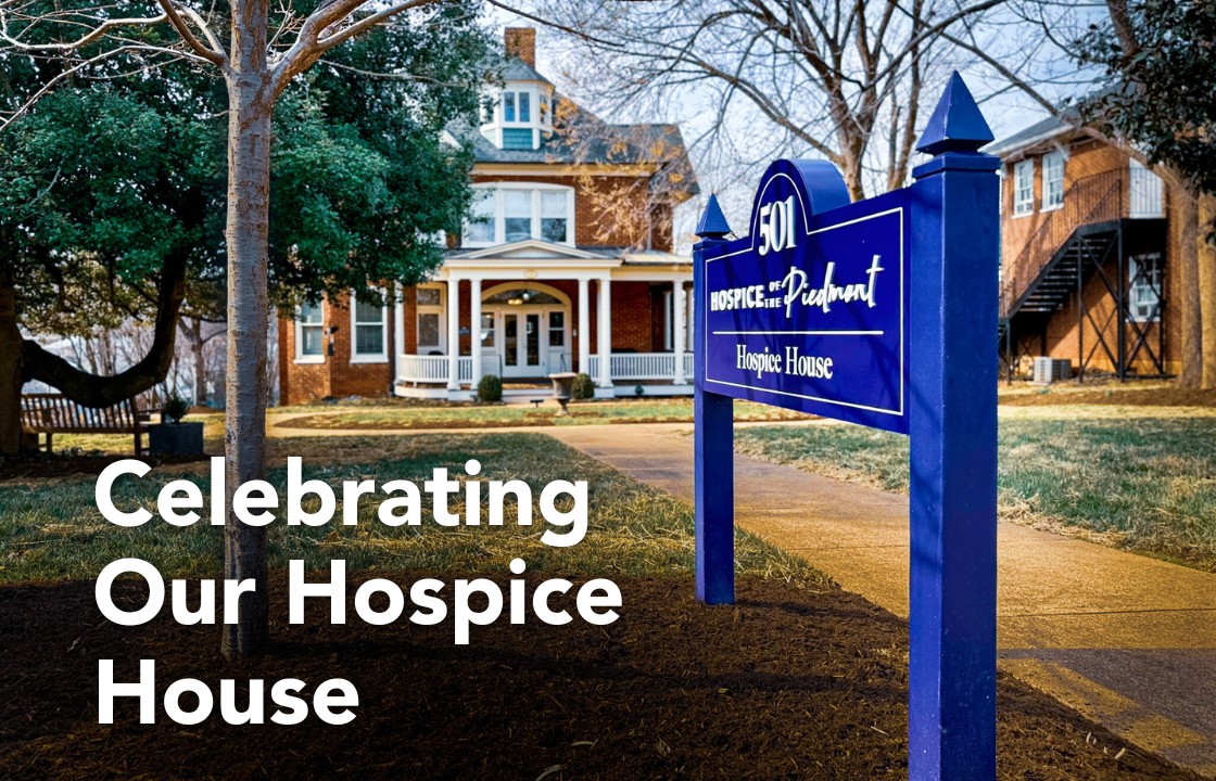 a photo of the hospice house renovation featuring the new bright blue sign in front of the 1904 Victorian home