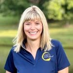 Hannah Barton, Hospice of the Piedmont's Community Navigator, wears a navy blue polo shirt with a Hospice of the Piedmont logo