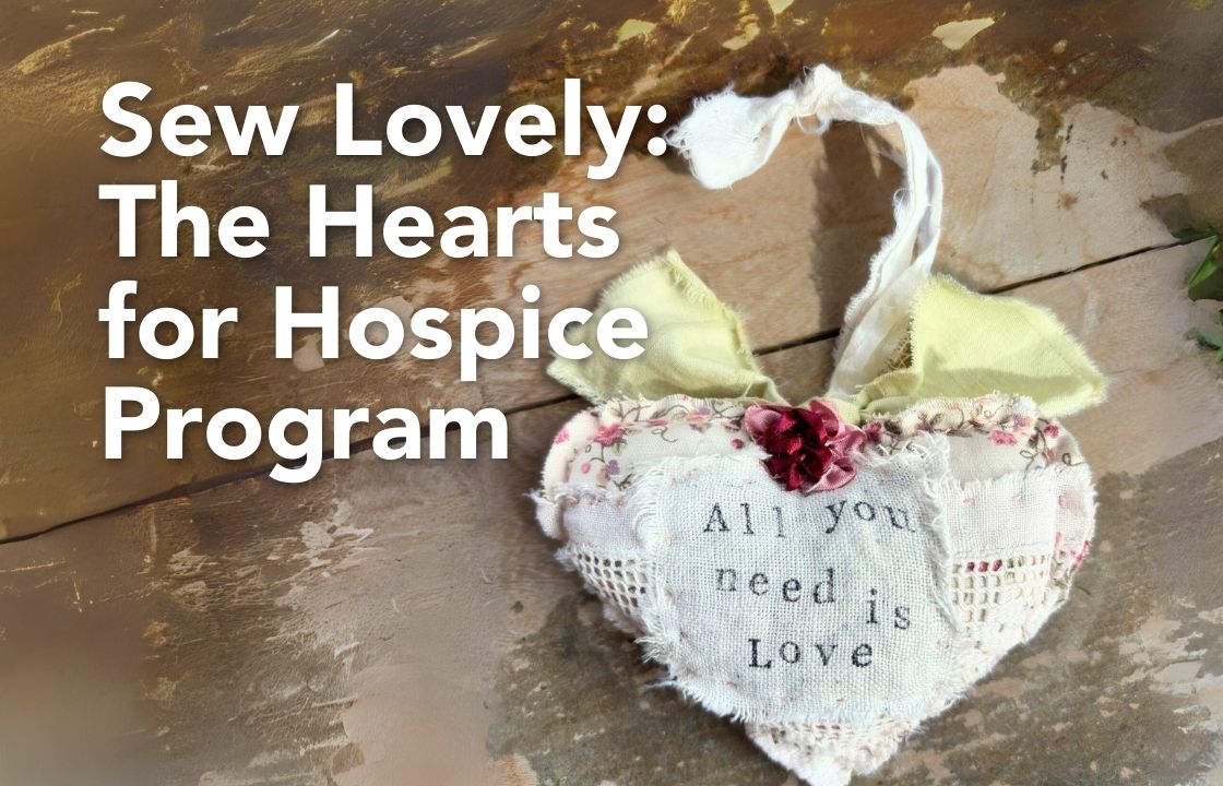 a hand-sewn "heart for hospice" - similar to a pillow-style Christmas ornament sits on an old wooden table