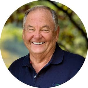 Bob Elliott smiles wearing a navy blue polo shirt