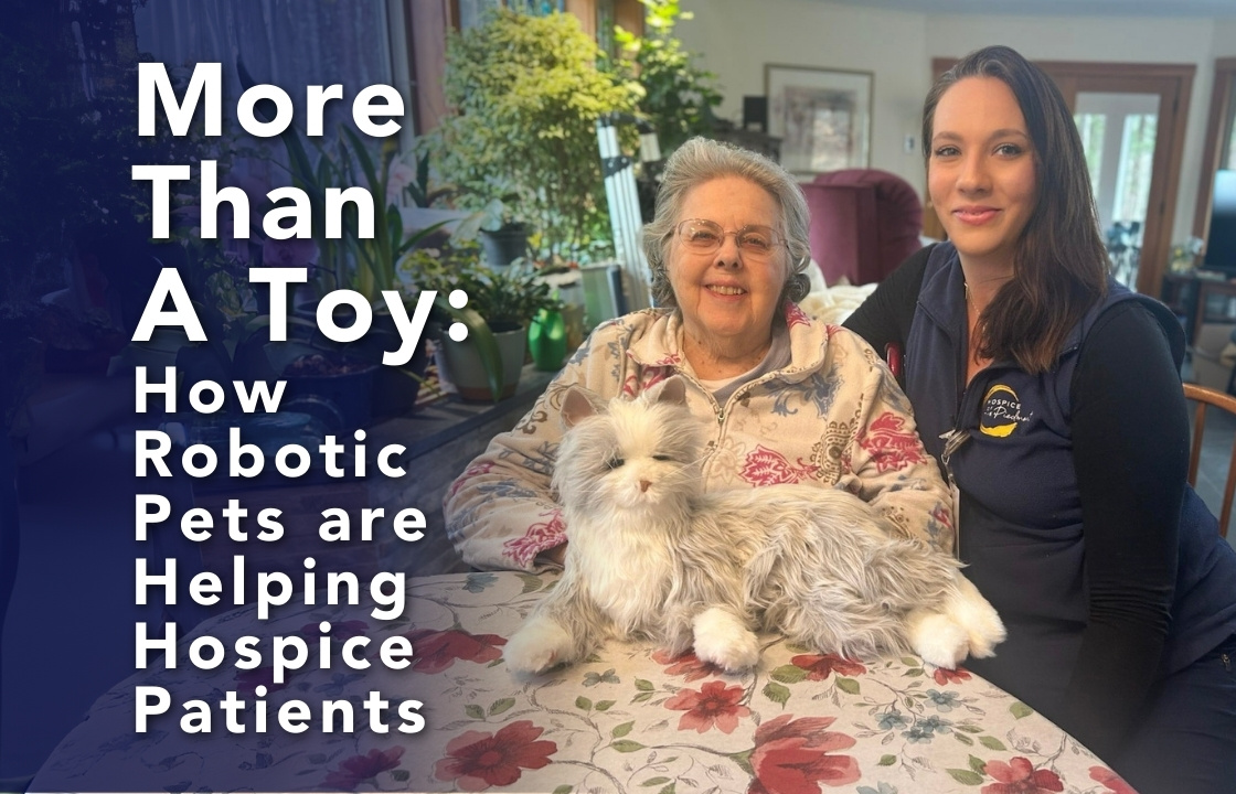 A hospice patient and her nurse sit with a silver and white robotic companion cat