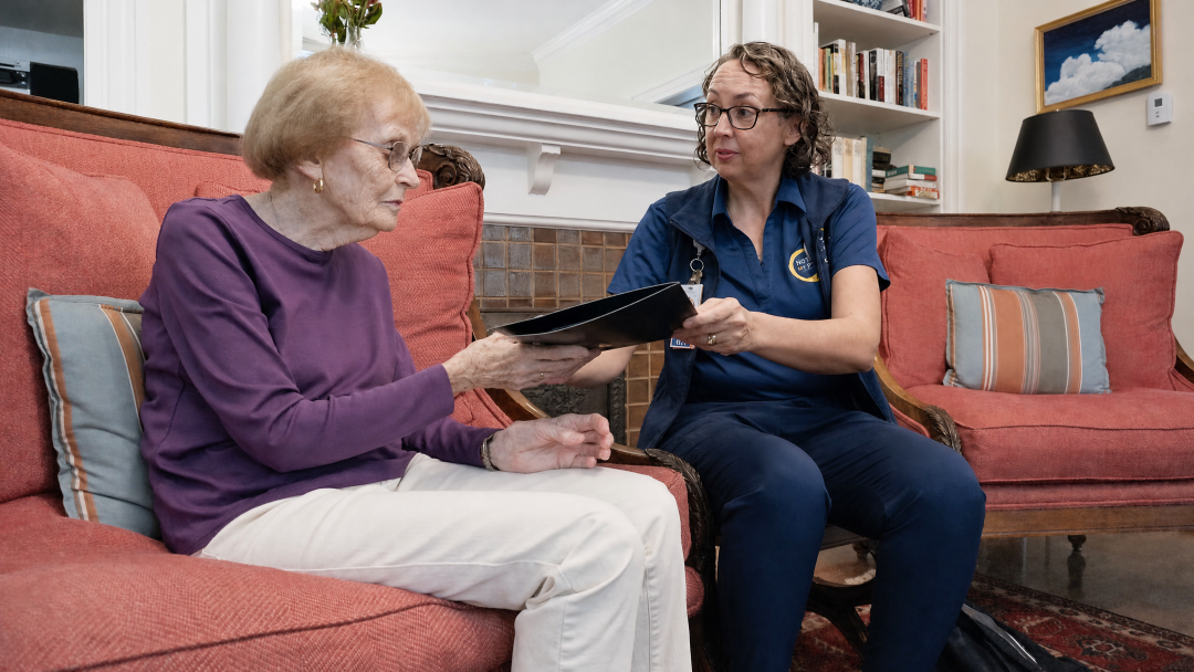 Hospice nurse reviewing information with a patient during an in-home visit.